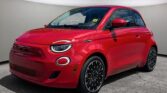 "Red Fiat 500e electric vehicle parked in a modern showroom with a sleek and compact design."