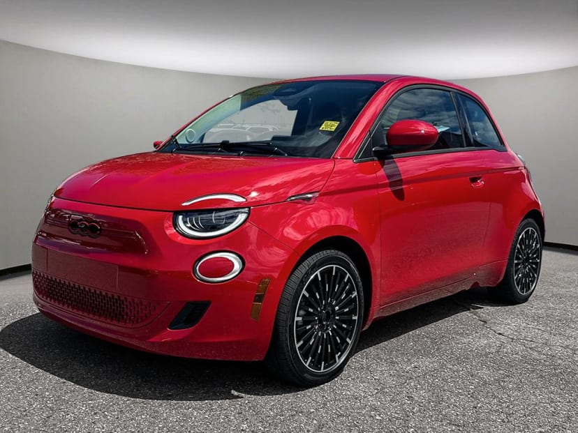 "Red Fiat 500e electric vehicle parked in a modern showroom with a sleek and compact design."