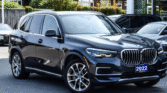 **"Front view of a black 2022 BMW SUV with a blue license plate reading '2022 Otto's' parked outdoors."**