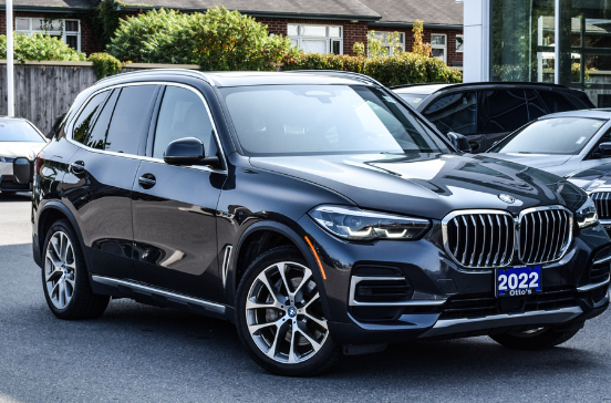 **"Front view of a black 2022 BMW SUV with a blue license plate reading '2022 Otto's' parked outdoors."**