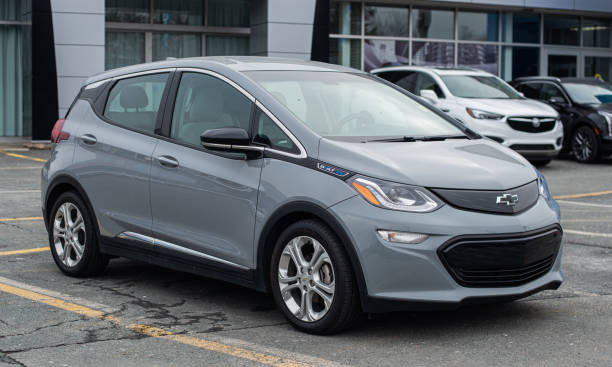 A gray Chevrolet Bolt EV parked in a dealership lot, showcasing its compact electric hatchback design